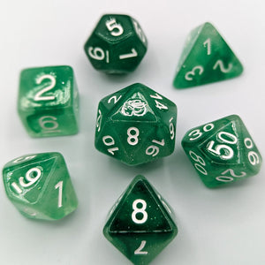 Semi transparent green dice with a mix of light to dark green pattern and slight glitter. White Font with Talys Dragon. 7 Piece Standard Size Dice Set