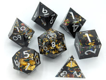 Load image into Gallery viewer, Black nebula design with most the color on one half of the dice set. Large gold flakes and multi-color flakes throughout to create a look similar to an old computer screen