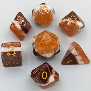 Solid color layers with chocolate brown, then marshmallow white, and graham cracker light brown. Gold font with Talys Dragon. 7 Piece Standard Size Dice Set