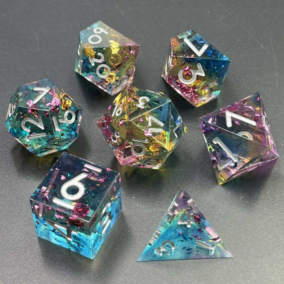Transparent light blue, then light yellow, then light pink layers. Medium sized gold, pink, and blue flakes throughout the dice